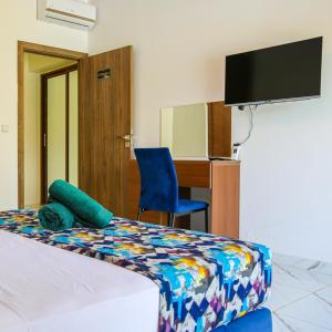 马拉喀什Hotel Jnane riad的一间卧室配有一张床、一张书桌和一台电视