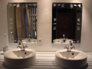费瑞雷斯La Cense De Renière的浴室设有2个水槽和2面镜子