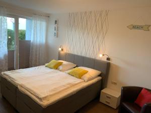 奥斯赛拜-屈隆斯博恩Yachthafenresidenz-Wohnung-8106-9412的一间卧室配有一张带两个黄色枕头的床