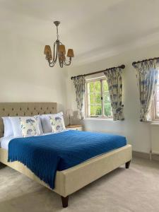 BuckinghamshireDenham Mount的一间卧室设有蓝色的床和窗户。