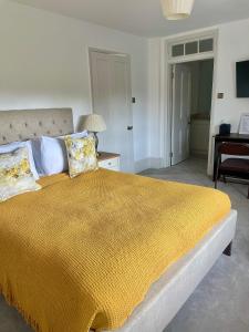 BuckinghamshireDenham Mount的一间卧室配有一张带黄色毯子的大床