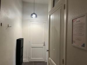 里昂Suite Lavani的一条带白色门和吊灯的走廊