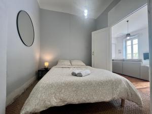 里昂Suite Lavani的白色卧室设有一张大床和镜子