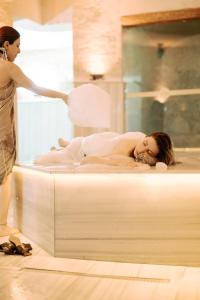 于尔居普卡帕多西亚弗雷斯科窟套房酒店的女人在洗床上的女人