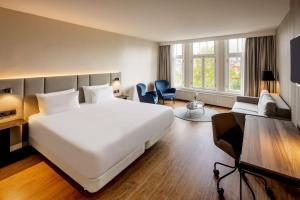 阿姆斯特丹阿姆斯特丹席勒NH酒店的一间带白色大床的卧室和一间客厅