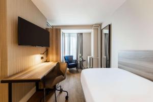 阿姆斯特丹阿姆斯特丹席勒NH酒店的配有一张床和一张书桌的酒店客房