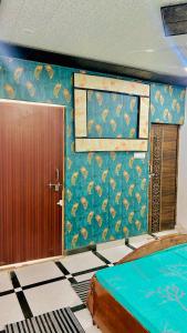 马图拉Radhey Krishna home stay的一间房间,设有门和一面墙,墙上贴着孔雀壁纸