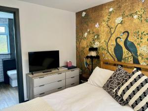 淡水Lovely independent 1-Bed Apartment in Freshwater的一间卧室配有一张床,墙上挂着鸟的壁画