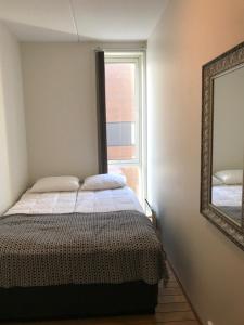 斯沃尔韦尔斯沃尔韦尔海港公寓酒店的一间卧室配有一张带镜子的床和窗户