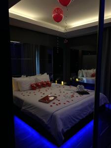PerafitaMotel Flamingo的一间卧室配有一张大床,上面装有红色气球