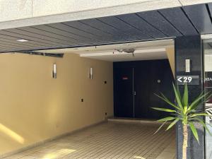 PerafitaMotel Flamingo的走廊上设有黑色的门和植物