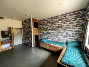 比迪福德Adventure Lodges and Retreats的一间设有两张床和砖墙的房间