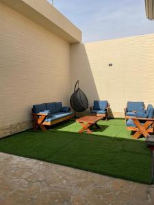 Bawḑahشالية الفهد的一个带野餐桌和椅子的草地庭院