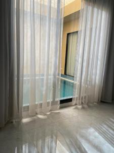 Bawḑahشالية الفهد的客房设有带游泳池和窗帘的窗户。