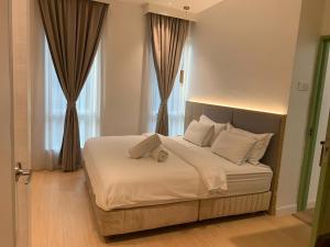 八打灵再也AP Concept Hotel的一间卧室配有带白色床单和枕头的床。