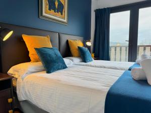 宏达瑞比亚Villa Higer的一间卧室设有两张带蓝色墙壁和窗户的床。