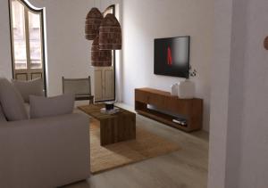 赫罗纳El Refugi de Girona的客厅配有电视、沙发和桌子