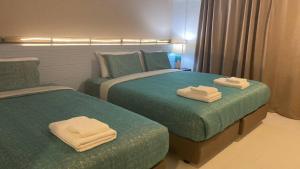 Lang SuanJeboutiquelangsuan hotel的两张位于酒店客房的床,配有毛巾