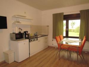 Usedom TownFerienhof Gliesner的厨房配有桌子、桌子和微波炉
