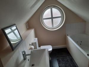 索利赫尔Stunning 5-bed ensuite House Solihull的一间带水槽和圆形窗户的浴室
