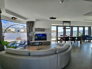 MġarrMalta Unique Penthouse Spacious Terrace-Sleeps 8的一间带大沙发的客厅和一间餐厅