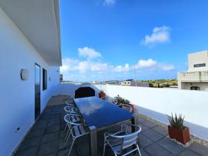 MġarrMalta Unique Penthouse Spacious Terrace-Sleeps 8的屋顶上带桌椅的天井