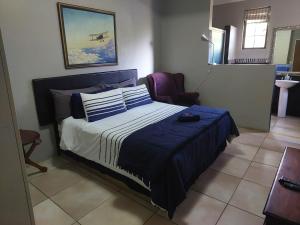 比勒陀利亚Garrett Guest House的一间卧室配有一张带蓝色棉被的床