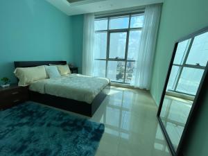 阿吉曼Luxurious Sea View - Beach Front的一间卧室设有一张床和一个大窗户