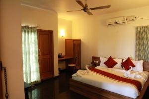 班加罗尔ZIONS AIRPORT HOTEL AND APERTMENT! Near Kempegowda International Airport的一间卧室配有一张床和吊扇