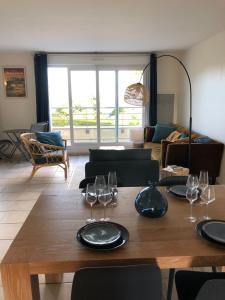 卡朗泰克Appartement vue mer à 100m de la plage au centre de Carantec的客厅配有带酒杯的木桌