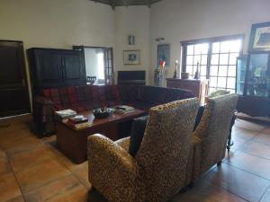 比勒陀利亚Garrett Guest House的客厅配有沙发和桌子