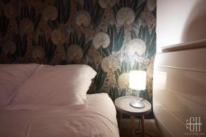图尔Le Fidji / 100m Gare的一间卧室配有一张床和一张带台灯的桌子