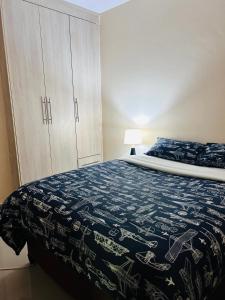 卢萨卡Tranquil Room in Apartment的一间卧室配有一张带蓝白色毯子的床
