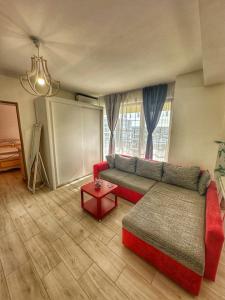 克拉约瓦Fancy Apartament Promenada Mall的客厅配有红色的沙发和桌子