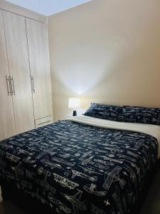 卢萨卡Tranquil Room in Apartment的一间卧室配有一张带蓝毯的床和橱柜