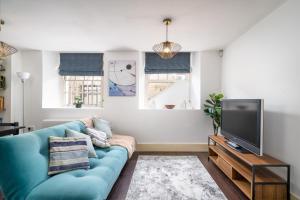 东莫尔西Riverside 1 Bed Flat near Hampton Court Palace的客厅配有蓝色的沙发和电视