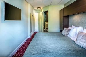 阿姆斯特丹阿姆斯特丹亚特兰蒂斯酒店的酒店客房,设有一张带平面电视的床铺。