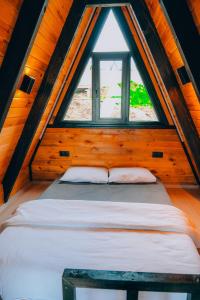 萨潘贾Mouna Sapanca的木制客房的一张床位,设有窗户