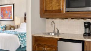 棕榈滩Hotel Aruba的带水槽的厨房和1间带床的房间