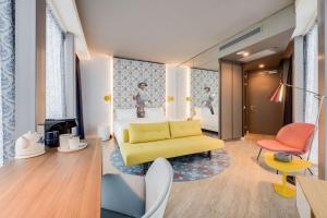 阿姆斯特丹nhow Amsterdam Rai的酒店客房设有一张黄色的沙发和一间卧室。