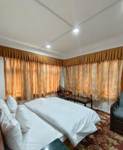 帕哈尔加姆Royal galaxy的卧室配有一张白色的大床和一张沙发。