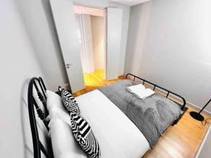 里斯本New Flat at Marques de Pombal的一间卧室配有一张带黑白枕头的床