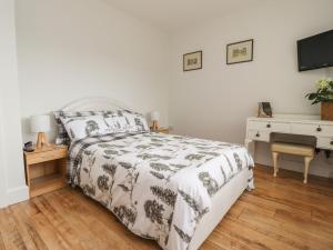 莱瑟姆-圣安妮14 Berwick Road的一间卧室配有一张床、一张书桌和一台电视