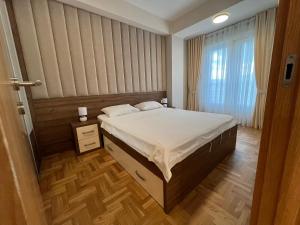 波德戈里察Apartments 28的一间卧室设有一张床和一个窗口