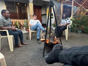 阿鲁沙Safari villa的一群人坐在椅子上,围着火炉