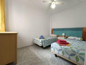 圣胡安海滩Casita La Ballena Tenerife Sur的一间卧室配有两张床和吊扇