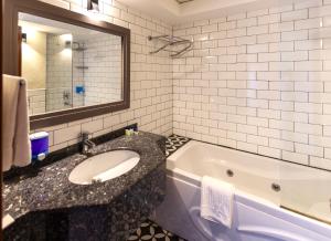 安塔利亚Mene City Hotel的浴室配有盥洗盆和浴缸。