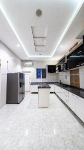 拉各斯Where Luxury Meets Comfort的一间大厨房,配有白色的橱柜和一台冰箱