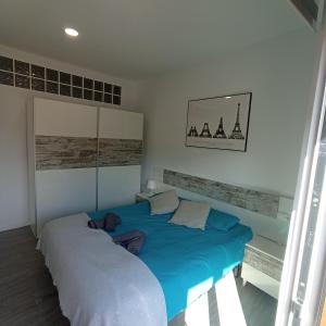 巴古尔Apartament al cor de Begur的一间卧室配有两张蓝色床单