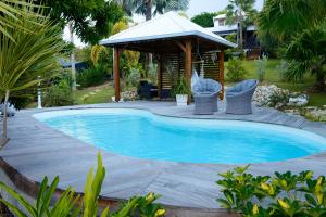 圣弗朗索瓦Résidence Mapou : Bungalow Cycas - logement de charme avec piscine的一个带凉亭的庭院内的游泳池